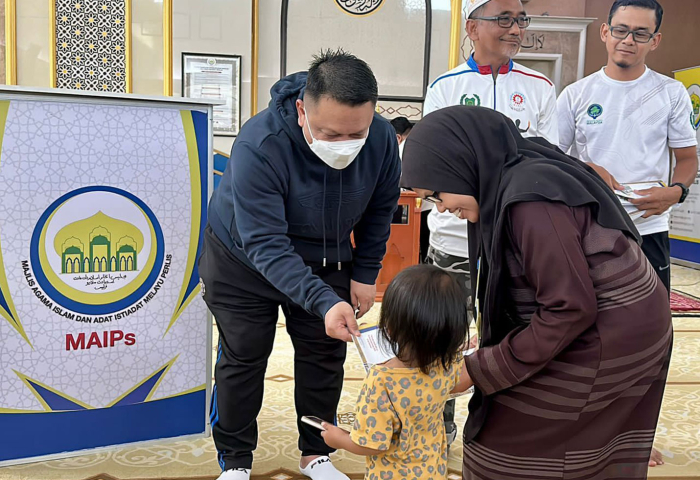  Tuanku Syed Faizuddin Putra berkenan mengurniakan sumbangan bantuan MAIPs yang diterima oleh seorang kanak-kanak bersama ibunya pada Majlis Penyerahan Agihan Zakat MAIPs di Masjid Al-Hidayah, Titi Beratap, Behor Mali, Simpang Empat, Perlis.